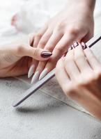 mains d'une jeune femme avec une manucure blanche sur les ongles photo