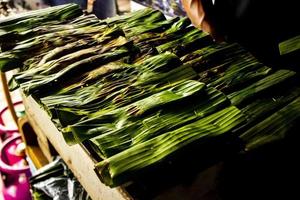 otak - otak est un aliment à base de viande de poisson de maquereau hachée enveloppée dans des feuilles de bananier, cuite au four et servie avec une sauce épicée et aigre. otak-otak est un gâteau de poisson traditionnel d'indonésie photo