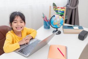 petite fille asiatique à la maison faisant ses devoirs photo