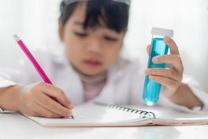 concept d'éducation, de science, de chimie et d'enfants - enfants ou étudiants avec expérience de fabrication de tubes à essai au laboratoire de l'école photo