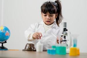 concept d'éducation, de science, de chimie et d'enfants - enfants ou étudiants avec expérience de fabrication de tubes à essai au laboratoire de l'école photo