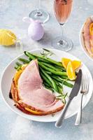 jambon cuit au four de pâques servi sur une assiette avec des haricots verts photo