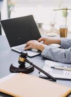 concept de justice et de droit. juge masculin dans une salle d'audience sur une table en bois et conseiller ou avocat masculin travaillant au bureau. concept de droit, de conseil et de justice juridique. photo