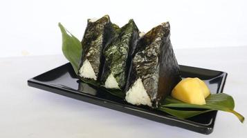 l'onigiri est la nourriture japonaise, la boule de riz japonaise, le triangle de riz aux algues, le nori isolé sur fond blanc photo