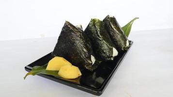 l'onigiri est la nourriture japonaise, la boule de riz japonaise, le triangle de riz aux algues, le nori isolé sur fond blanc photo