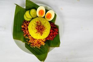 nasi kuning ou riz jaune ou riz au curcuma est une cuisine traditionnelle d'asie, faite de riz cuit avec du curcuma, du lait de coco r photo