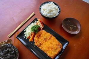 le poulet katsu don est une cuisine japonaise servie avec de la sauce soja sur la table photo