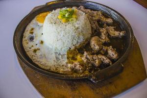 petit-déjeuner avec riz, oeuf au plat et viande ou boeuf avec garniture maïs et poireau gros plan plaque chauffante isolée sur fond blanc photo