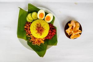 nasi kuning ou riz jaune ou riz au curcuma est une cuisine traditionnelle d'asie, faite de riz cuit avec du curcuma, du lait de coco r photo