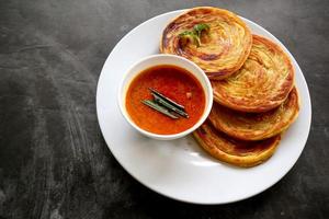 pain paratha ou pain canai ou roti maryam, plat préféré du petit-déjeuner. servi sur assiette photo