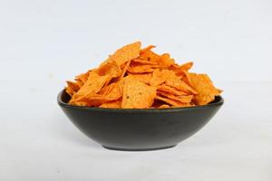 tortilla chips est des croustilles de maïs ou appelez des nachos, servis dans un bol, sur fond noir à base de maïs photo