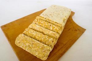 tempeh cru ou tempe. tranches de tempeh sur fond blanc. graines de soja crues. Le tempe est un aliment traditionnel indonésien à base de soja fermenté. photo