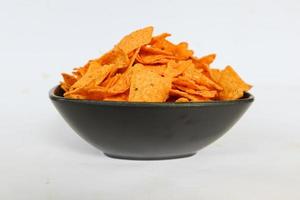 tortilla chips est des croustilles de maïs ou appelez des nachos, servis dans un bol, sur fond noir à base de maïs photo