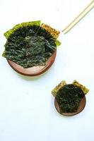algue nori isolé sur fond blanc. nori de cuisine japonaise. feuilles d'algues sèches. photo