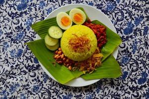 nasi kuning ou riz jaune ou riz au curcuma est une cuisine traditionnelle d'asie, faite de riz cuit avec du curcuma, du lait de coco r photo