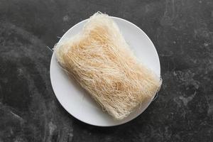 bihun sec cru ou vermicelles ou nouilles de riz ou cheveux d'ange isolés sur fond blanc photo