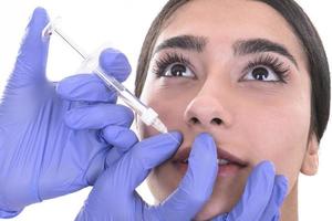 une jeune femme reçoit une injection de botox. injection anti-âge photo