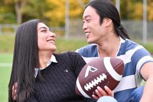 couple mixte dans le parc jouant au football américain. football américain. couple jouant au rugby. photo