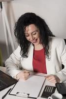 femme d'affaires heureuse essayant de travailler dans son bureau photo