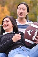 couple mixte dans le parc jouant au football américain. football américain. couple jouant au rugby. photo