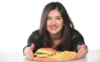 portrait d'une belle jeune fille drôle mangeant un hamburger photo