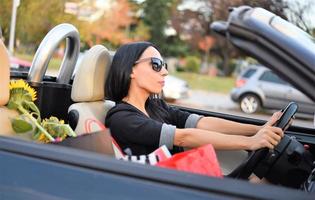 heureuse belle femme au volant d'une voiture de sport dans la ville photo