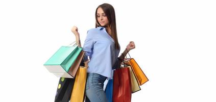 notion d'achat. belle brune souriante avec des sacs à provisions posant sur fond blanc photo