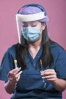 femme médecin asiatique en gros plan portant un écran facial et une combinaison d'epi pour l'épidémie de coronavirus photo