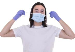 modèle masculin asiatique portant et tenant un masque chirurgical et des gants de protection photo