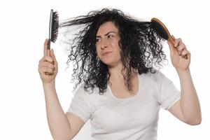 Belle femelle avec un peigne coincé dans les cheveux bouclés photo