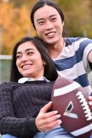 couple mixte dans le parc jouant au football américain. football américain. couple jouant au rugby. photo