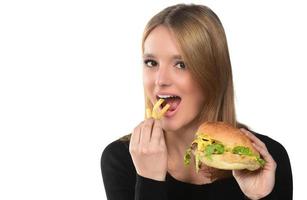 portrait d'une belle jeune fille drôle mangeant un hamburger. photo