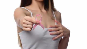 concept de soins de santé et de médecine. main de femme tenant un ruban rose de sensibilisation au cancer du sein. photo