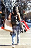 belle femme marchant dans la rue avec des sacs à provisions. modèle féminin à la mode dans la ville tenant des sacs à provisions. photo
