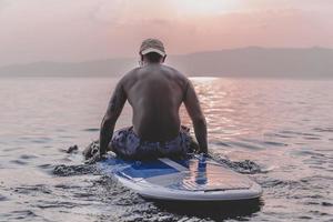 bel homme sportif fait du kayak au coucher du soleil photo