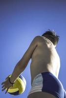 un enfant joue au volley-ball par une belle journée d'été photo