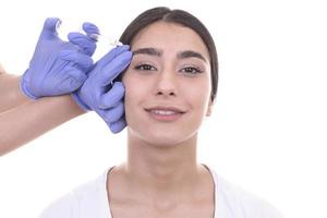 une jeune femme reçoit une injection de botox. injection anti-âge photo