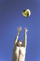 un enfant joue au volley-ball par une belle journée d'été photo