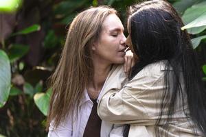 un couple de femme gay souriant et s'embrassant. même sexe jeune couple de femmes mariées dans leur routine quotidienne montrant une certaine affection lgbt photo