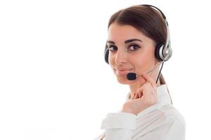 belle jeune femme d'affaires brune avec un casque et un microphone souriant isolé sur fond blanc photo