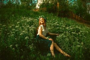 fille avec joli sourire posant dans l'herbe photo