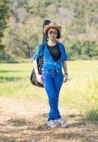 femme portant un chapeau marchant et portant son sac de guitare photo