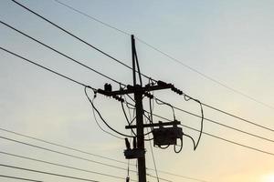 Le pôle électrique moyenne tension consommateur est le peuple qui utilise l'énergie et la petite industrie dans l'atmosphère chaleureuse et romantique du ciel du soir. photo