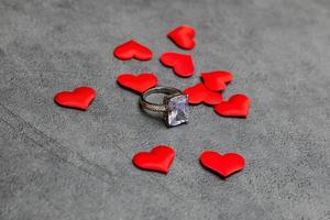 veux-tu m'épouser. bague de mariage de nombreux coeurs rouges sur fond gris pierre béton. concept de mariage de proposition de mariage de fiançailles. St. carte postale de la saint valentin. bannière le jour de la saint valentin. photo