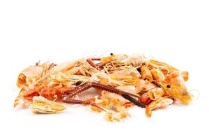 têtes de crevettes et carapaces de crevettes, déchets alimentaires, restes, déchets. fruits de mer naturels. déjeuner. dîner isolé sur fond blanc. photo