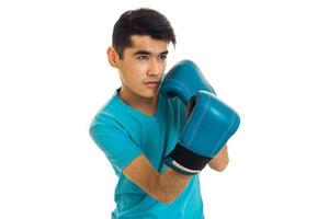 Jeune homme brune en gants de boxe bleu pratiquant isolé sur fond blanc photo