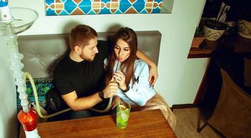 beau couple au bar à narguilé fume la chicha photo