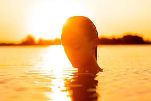 jeune femme sexuelle dans la mer au coucher du soleil chaud photo