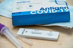 médecin en costume d'epi tenant un kit de test d'antigène salivaire pour vérifier le coronavirus covid19 à l'hôpital. photo