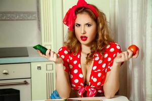 portrait de belle femme en style pin-up avec concombre et tomate dans les mains photo